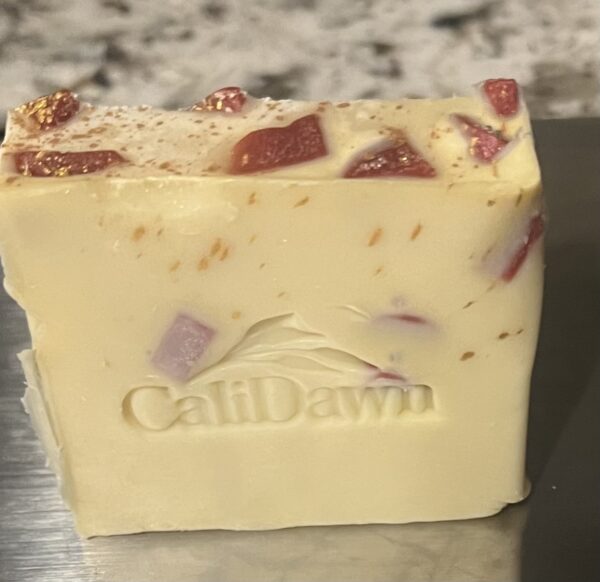 tan soap with small burgundy chunks inserted with gold sprinkles