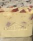 tan soap with small burgundy chunks inserted with gold sprinkles