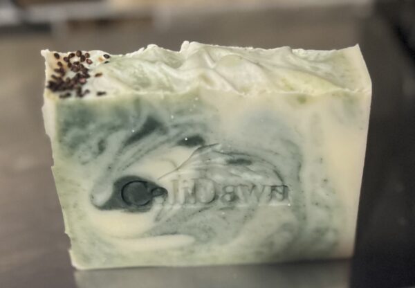Soap bar with green and tan swirls topped with cranberry seeds